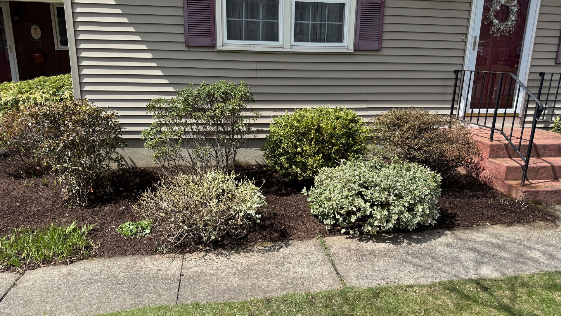 Residential house with landscaped front yard and mulched garden beds